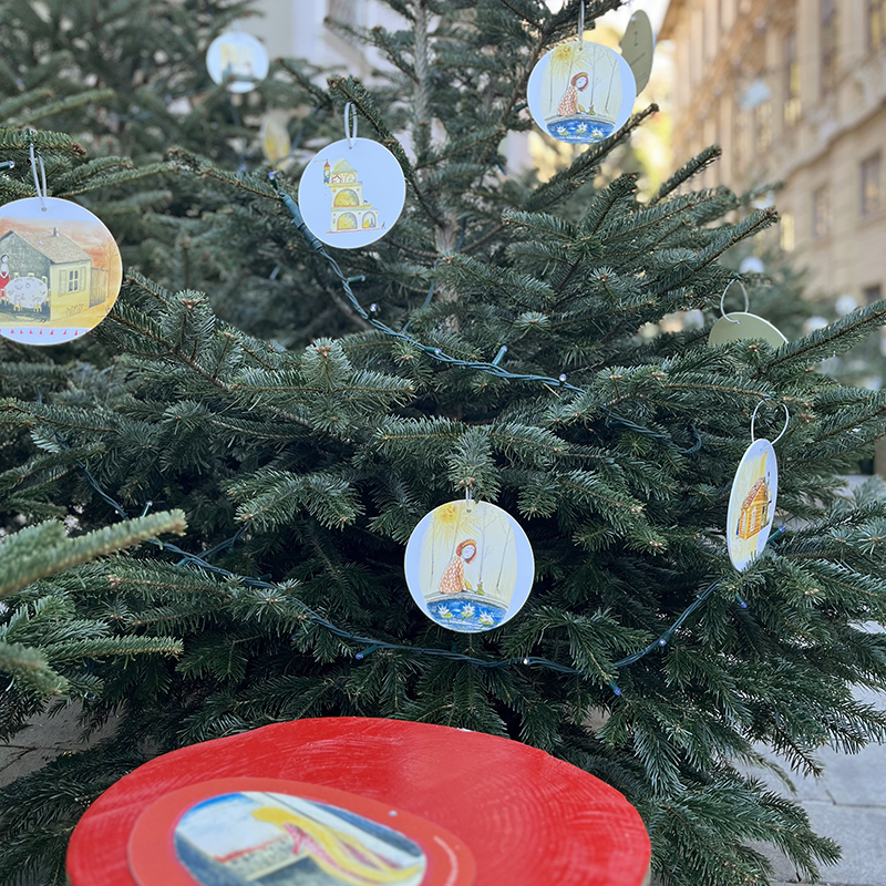 Märchenwald am Schloßbergplatz - Nadelbaum mit illustrierten Anhängern